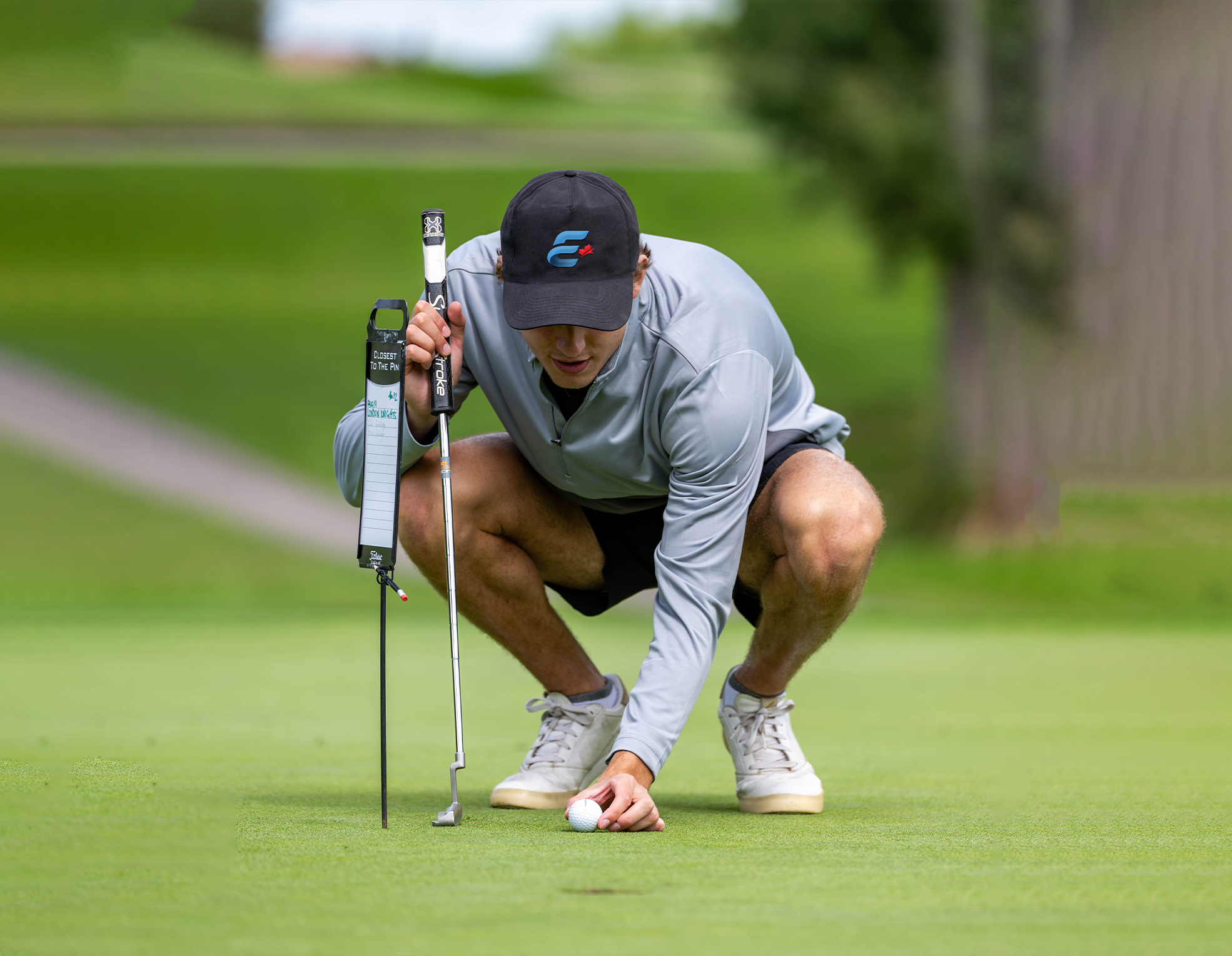 Golfer sets ball ready to putt on green